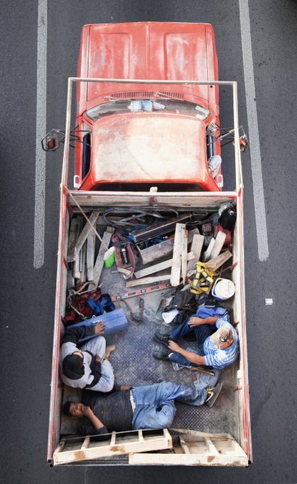 An aerial view shows workers resting in the back of a red pickup truck loaded with tools and lumber, a scene from Alejandro Cartagena's "Carpoolers" photography series. The image was minted as NFT #1 by collector @halecar2 on Verse for Ξ1 (~$1,576).