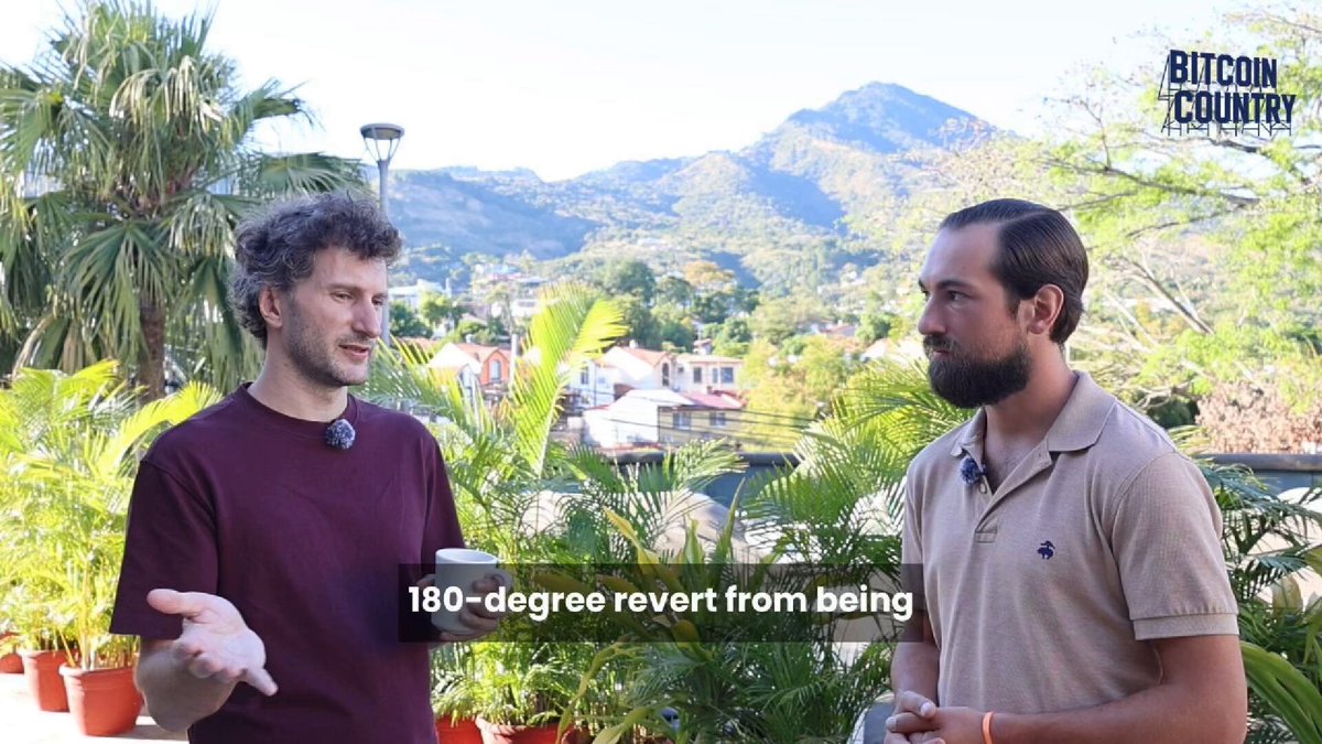 The image shows two men standing next to each other, engaged in a conversation. They are positioned near potted plants, which add greenery to their surroundings. The background of the image features mountains, providing a scenic backdrop for the scene. The text on the image includes phrases such as "bitcoin adoption has two main fronts: grassroots and TradFi.", "@nicolasburtey has rare expertise with both.", and "@GaloyMoney onboards banks to BTC. They also created @blinkbtc wallet for circular economies like @Bitcoinbeach We discussed both and more at the Bitcoin Capital Summit". The image seems to be a promotional post or advertisement related to Bitcoin adoption, featuring two men discussing the topic in front of potted plants with mountains in the background.