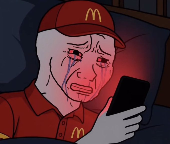 A melancholic Wojak-style cartoon character wearing a McDonald's uniform and cap, crying red and blue tears while staring at a glowing smartphone in bed.