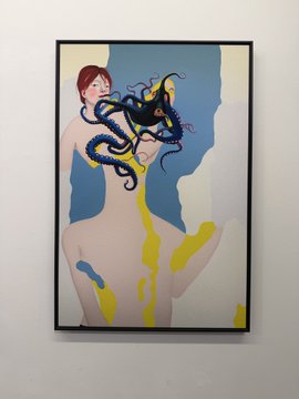 A framed painting on a wall depicts a nude figure with an octopus or tentacled creature on their head, with blue and yellow paint drips running down the body.