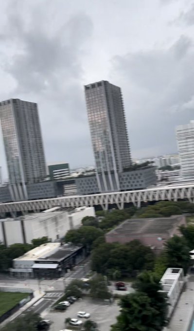A cloudy urban skyline featuring tall skyscrapers and an elevated roadway/train track, likely a financial or business district. The image appears unrelated to the post's message about sending $SOL cryptocurrency, serving only as a backdrop with no visible crypto or text content relevant to the giveaway claim.