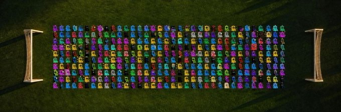 A colorful grid of hundreds of pixel-art robots arranged in neat rows on a green surface, flanked by two metallic bench-like objects, represents the "20 GTD Spots" giveaway for @netmachines_, a blockchain-based NFT robot collection where participants must submit their EVM wallet within the 2-hour window for a chance to win a guaranteed spot in the drop.