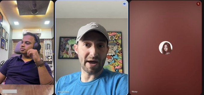 A screenshot of a three-panel video call showing two men on video (one labeled 'KoraPeeble' wearing a cap, the other listening with headphones) and a third participant ('Niccy') showing only a profile icon.