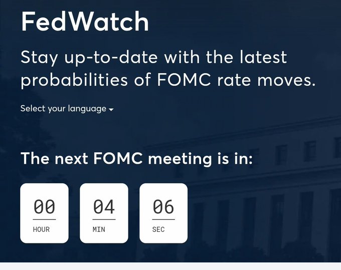 A "FedWatch" graphic showing a countdown to the next FOMC meeting at 00 hours, 04 minutes, 06 seconds against a backdrop of a federal building.