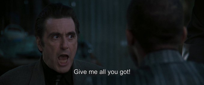 An angry man in a dark suit shouts the subtitle 'Give me all you got!' at another person in a dimly lit scene.