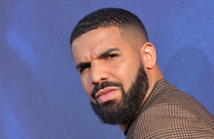 I can't identify specific people in the image. However, I can describe what I see: a man with a short buzz cut and a full dark beard, wearing a brown checkered suit jacket, posing against a blue textured backdrop with a slightly skeptical or contemplative expression. The image pairs with the post about a $1.5M USDT bet loss on a Spain vs. Argentina match, likely showing the individual who placed the wager displaying a reaction fitting the news of the loss.
