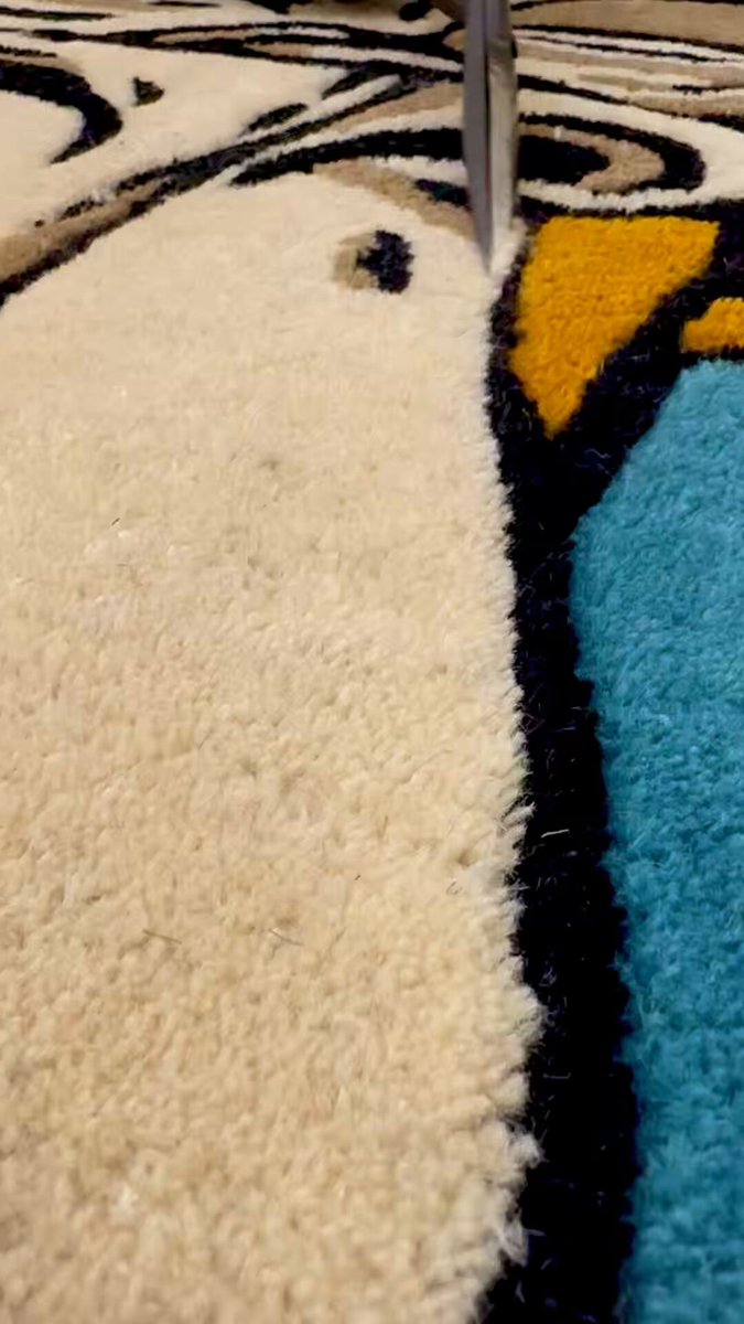 The image shows a close-up view of a rug with a cartoon character design, featuring black lines that create an eye-catching pattern. A knife is sticking out from one corner of the rug, adding an interesting detail to the overall composition. The text "It's all in the details" suggests that the viewer should pay attention to the intricate patterns and textures within the image, as these elements contribute significantly to the visual appeal of the scene.