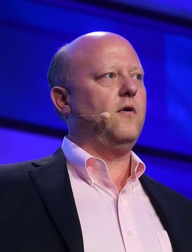 A bald man wearing a dark suit jacket over a pink button-up shirt speaks at a podium with a headset microphone, appearing to be giving a presentation or address. Given the context, this is likely Jeremy Allaire, the Circle CEO, responding to criticism from Coinbase and other firms backing a rival to his company's USDC stablecoin.