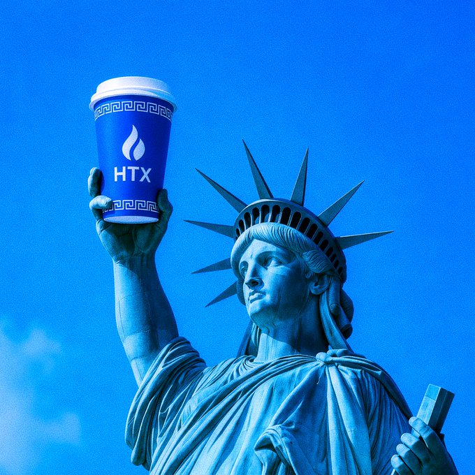 A stylized blue-toned image of the Statue of Liberty holding up a paper cup branded with the 'HTX' cryptocurrency exchange logo in place of her torch.