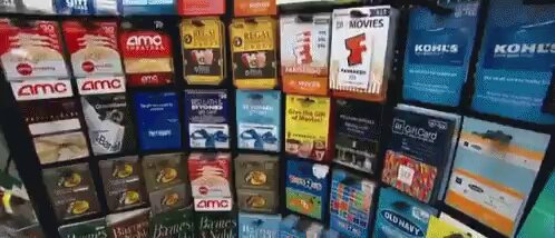 The image shows a display of various gift cards for different stores such as AMC, Kmart, and Best Buy. The cards are organized by store name and color, with some being red, blue, green, and yellow. The text on the image suggests that users can easily turn their crypto into these gift cards using an app called @bitrefill.