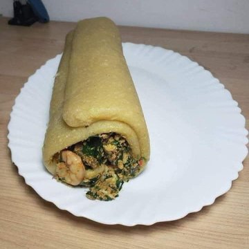 A stuffed tortilla wrap filled with beans, greens, and other fillings sits on a white plate, representing a "taco" inspired meal despite not resembling a traditional taco.

The image has no clear connection to the Sleepagotchi mission text, which focuses on sleep and rest rather than food.