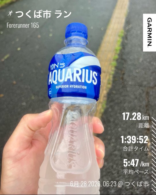 The post mentions being soaked and drenched, with a #STEPN reference, suggesting the runner got caught in the rain during their workout. This is reflected in the image showing a sweaty, clammy hand gripping a half-consumed Aquarius sports drink bottle after a 17.28 km run in Tsukuba on June 28, 2026, with an average pace of 5:47/km as tracked by a Garmin Forerunner 165—explaining the need for hydration and a change of clothes.