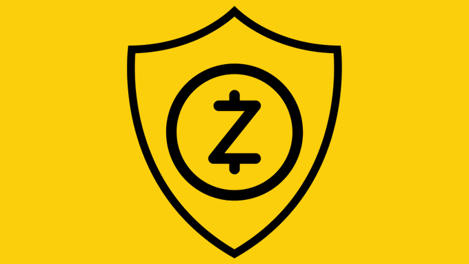 A simple yellow and black logo featuring a shield outline containing a circular emblem with a stylized 'Z' inside.