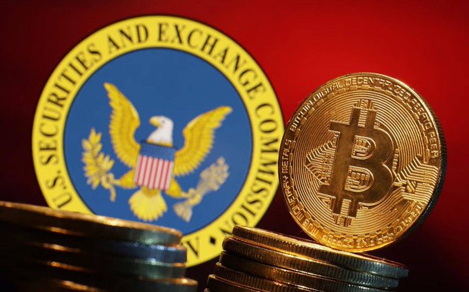 A photograph displays physical Bitcoin coins stacked in the foreground against the backdrop of the U.S. Securities and Exchange Commission (SEC) seal.