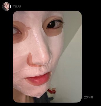 A close-up selfie of a person wearing a white sheet face mask with cutouts for the eyes, nose, and mouth, posted from a Snapchat account labeled "YUJU" at 23:48.