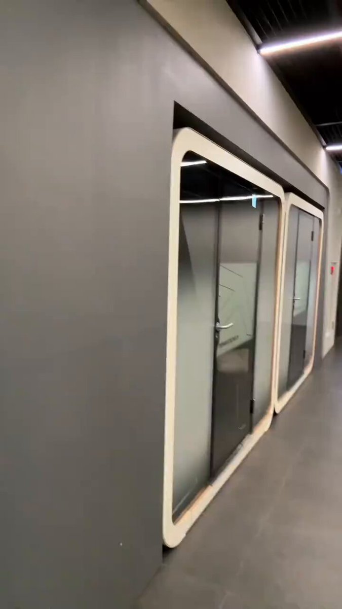 The image shows a hallway with two doors, one of which has a glass window while the other does not. The door without a window appears to be made of wood or metal, possibly a sliding door. The hallway seems to be empty at the moment, as there are no people visible in the photo.