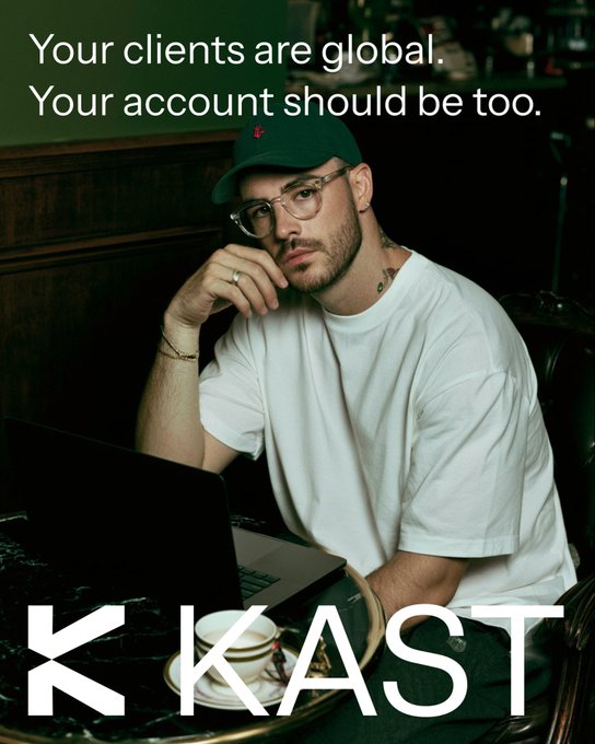 A young man wearing a green cap, glasses, and a white t-shirt sits at a café table with a laptop, under the headline "Your clients are global. Your account should be too." alongside a "KKAST" logo, reinforcing the ad's message about borderless banking for globally connected freelancers and professionals.