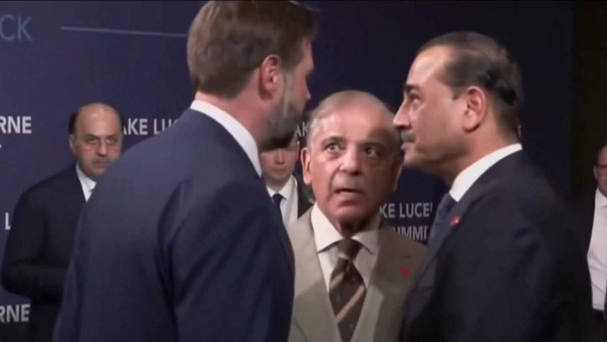 The image shows two men dressed in suits, one wearing a blue suit and the other wearing a black suit, standing next to each other with their heads close together as if they are having an intense conversation or discussion. The background of the image is blurred, but there are several people present who appear to be engaged in various activities such as talking or walking around.

The post that accompanies this image reads: "BAYC known  market red red red deep red". This phrase seems unrelated to the main focus of the image - the two men in suits and their conversation, but it adds an interesting detail for viewers who may be curious about what is happening in the background.
