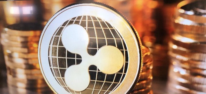A close-up of a gold Ripple (XRP) cryptocurrency coin surrounded by stacks of similar coins, symbolizing the $250,000 investment Ripple is making to support 25 veteran- and military-spouse-owned businesses with $10,000 grants each.
