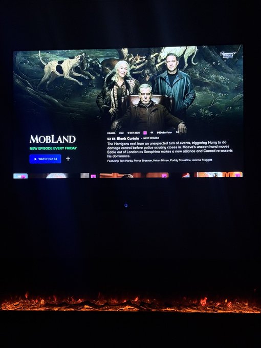 A Paramount+ streaming interface displayed on a TV showing the series 'MobLand' with Tom Hardy, Helen Mirren, and Pierce Brosnan, indicating S1 E6 'Blank Curtain' and 'New Episode Every Friday.'