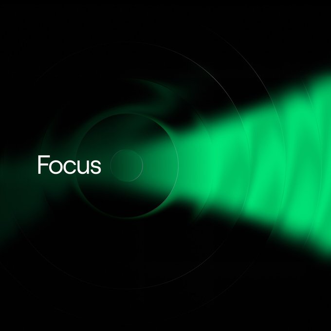 A minimalist graphic features the word 'Focus' in white text next to a glowing green camera lens against a black background.