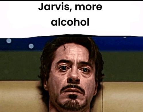 A meme featuring Robert Downey Jr. with a weary, exhausted expression and the text "Jarvis, more alcohol" at the top. The image humorously relates to the post by depicting the burnout of crypto veterans who've been grinding since 2020—drowning their fatigue in alcohol instead of celebrating early retirement like they once hoped.