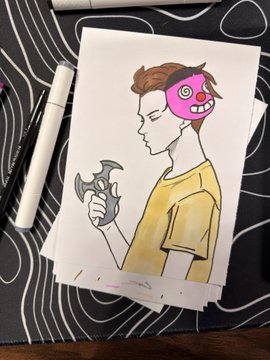A hand-drawn illustration on white paper showing a person with a pink monster/creature head holding a stylized bat or weapon, placed on a black surface with white line patterns next to a white pen.