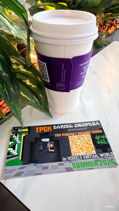 A coffee cup with a QR code sleeve next to a card reading 'TPGR DANIEL OROPEZA @paborotgars AT THE PEOPLE'S GALLERY in VOXELS VIRTUAL WORLD SUMMER 2026', with a plant in the background.