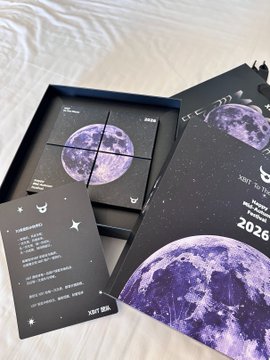An astronomical-themed product box set with purple moon graphics, containing multiple compartments and an instruction booklet, with 'Just The Beginning' and '2026' printed on the packaging.