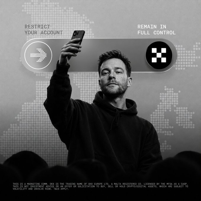 A man in a black hoodie takes a selfie with his phone against a digital world map backdrop, with "RESTRICT YOUR ACCOUNT" and "REMAIN IN FULL CONTROL" displayed on either side of him alongside OKX's logo. The black-and-white ad, fine print identifying OKX Europe Ltd. as a MiCA-licensed CASP, visually reinforces the post's message about OKX's regulated EU presence and crypto self-custody.