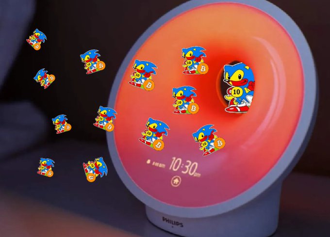 A Philips digital clock displaying 10:30 PM at night, with many Sonic the Hedgehog character stickers scattered around it.