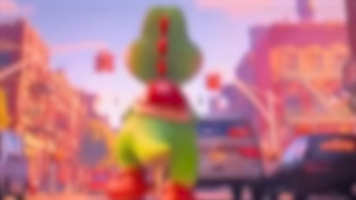 A green dinosaur statue with a red scarf and hat stands on a city street, surrounded by buildings and cars.