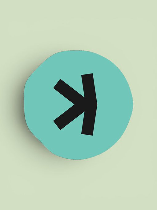 A teal circular token or coin displaying a black geometric logo resembling the XDC or a similar cryptocurrency symbol.
