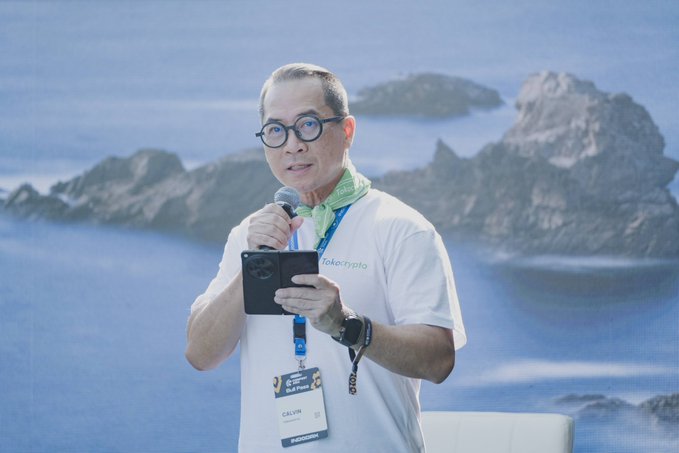 Calvin Kizana, CEO of Tokocrypto (wearing a "tokocrypto" shirt and "CEO" lanyard), speaks into a microphone at a forum, visually reinforcing the post's message about the maturing crypto industry through evolving regulations and innovations like tokenized stocks.