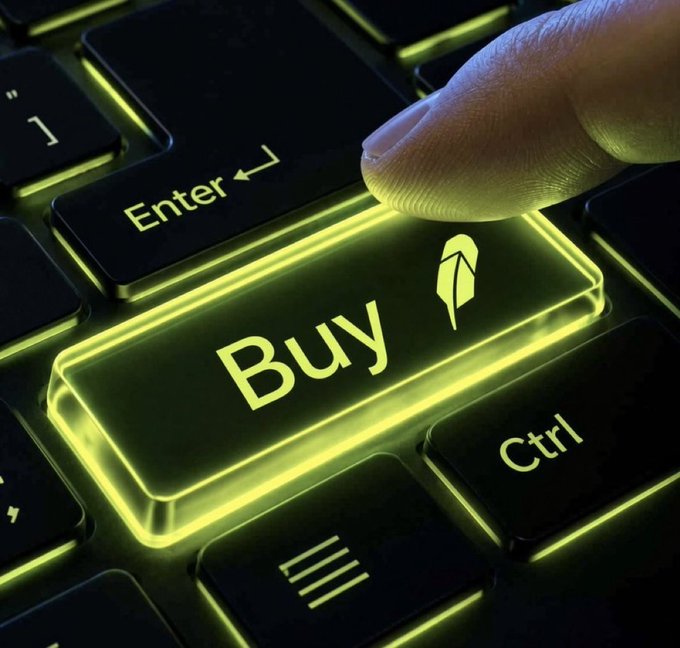 A close-up of a glowing yellow-green "Buy" key on a backlit keyboard, with a finger pressing down on it next to the "Enter" and "Ctrl" keys.
