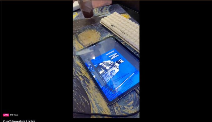A tablet displays a digital drawing of "INFEKTUS" in blue and white next to a keyboard, capturing the early creative process of what may become an $INFKT NFT collection during a livestream drawing session.