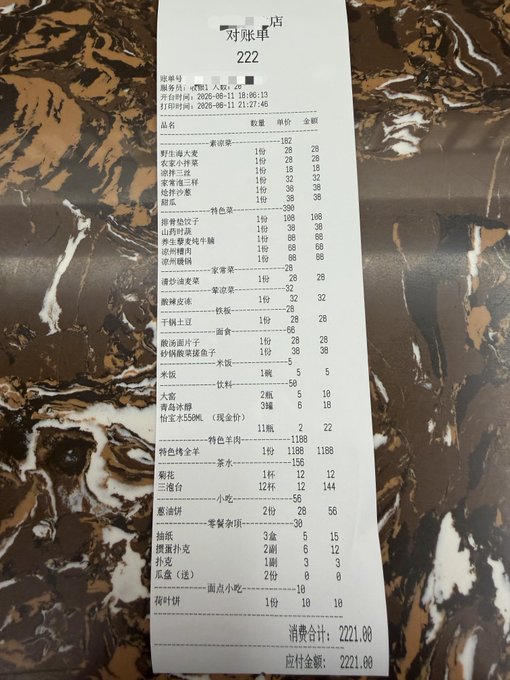 A Chinese restaurant receipt on a dark marbled surface, showing a bill totaling ¥2221.00 from what appears to be a beverage shop.