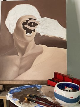 A work-in-progress painting of a stylized figure with a decorative mask/face design, with a paint palette, brushes, and a water cup visible in the foreground.