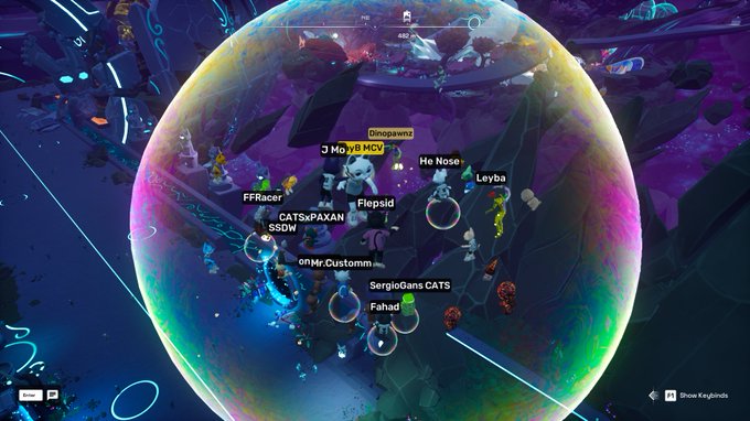 A colorful spherical virtual world in a video game displaying player names floating above avatars, including 'Dinopawnz', 'J MojyB MCV', 'He Nose', 'Levba', 'FFRacer', 'CATSxPAXAN', '$SDW', 'Flepsid', 'oNr.Customm', 'SergioGans CATS', and 'Fahad'.