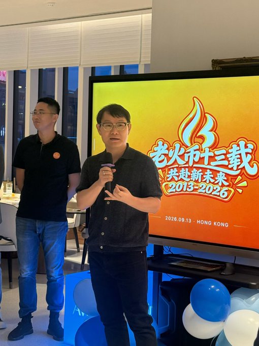 Two men at an event celebrating '老火汤十三载 共赴新未来 2013-2026', dated 2026.09.13 in Hong Kong, with the speaker holding a microphone in front of an orange flame-themed banner.