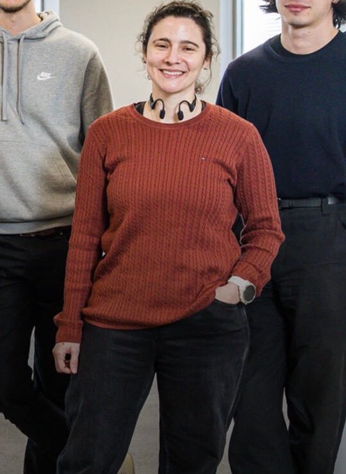 A smiling woman in a rust-colored Tommy Hilfiger sweater stands between two men, one in a gray Nike hoodie and another in a dark shirt. The image appears to be a casual group photo, though the context of the caption suggests the woman pictured may be connected to the Curaçao licensing revelations surrounding the Stake-Rainbet controversy involving Eddie Craven's sister.