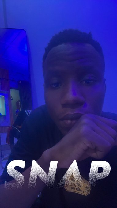 A young man poses for a selfie in blue lighting with a 'SNAP' text overlay and ticket graphic at the bottom.