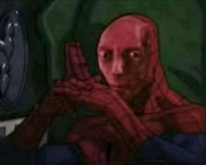 A bald humanoid figure with red-tinged skin stands with crossed arms in a dark, green-hued environment, gazing forward with a serious expression.