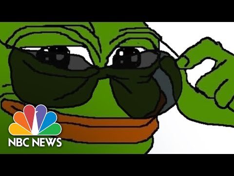 The image features a cartoon green frog wearing glasses and sunglasses, and appears to be looking at someone. A text overlay on the image reads "NBC News - Peacock". The image seems to be related to an event or discussion surrounding television coverage of peacocks, as indicated by this phrase in the text overlay.