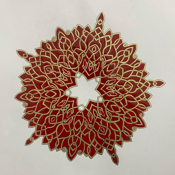 A circular red mandala-like artwork with intricate gold interlocking Celtic-style knotwork and pointed petal designs arranged around a hollow center on a white background.