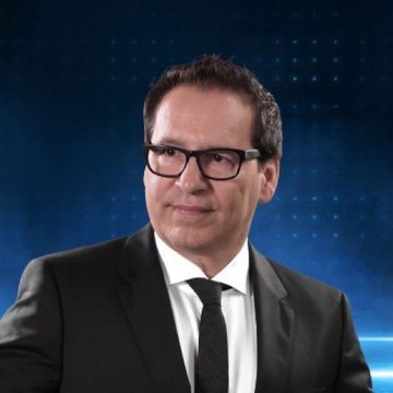 A middle-aged man in a dark suit, white shirt, and tie wears glasses against a blue digital background.