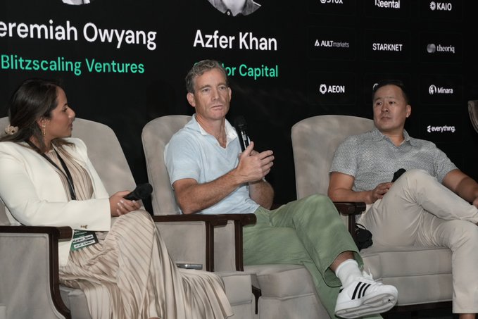 Three panelists sit on a stage during a discussion; visible backdrop text includes “Jeremiah Owyang,” “Azfer Khan,” “Blitzscaling Ventures,” “AEON,” “Starknet,” “KAIO,” and “everything.”