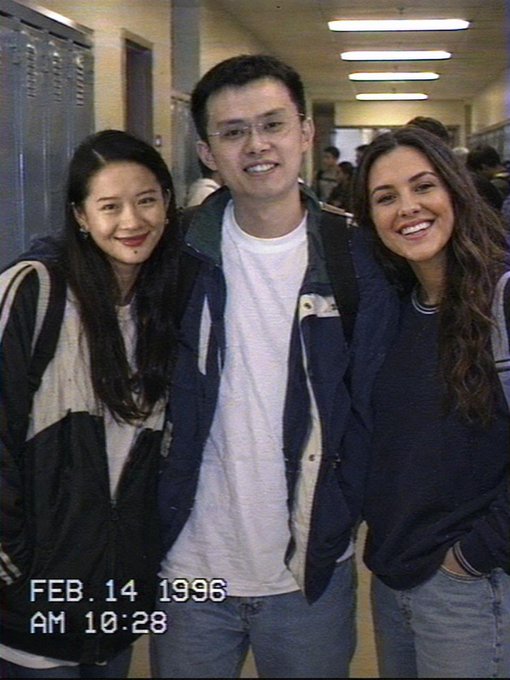 The image shows three people standing together, smiling for a photo. They are positioned in front of a locker room or hallway with lockers visible behind them. The caption reads "Before Bitcoin. Before binance. Just vibes." This suggests that they might be friends who have gathered to capture a moment and share it on social media platforms like Instagram.