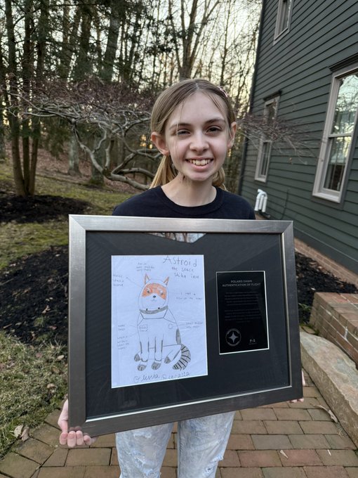 A smiling young girl proudly holds a framed piece titled "Asteroid: My Lucky Strike" featuring a drawing of an orange tabby cat in an astronaut suit, alongside a "POLARIS DENIED" plaque. The image ties into the post's theme by visually representing one of the many "Asteroid" IP variations across platforms like ETH, BSC, SOL, and Robinhood—serving as proof that the story holds real value worth contesting.