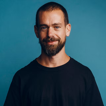 A portrait of a smiling bearded man wearing a black sweater against a teal-blue background.